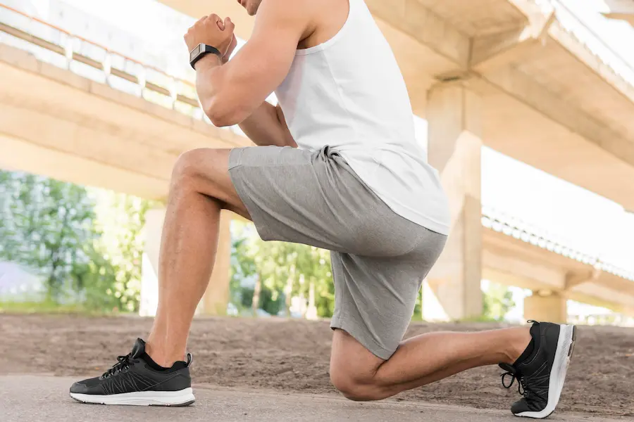Corredor haciendo estiramiento para prevenir lesiones de rodilla