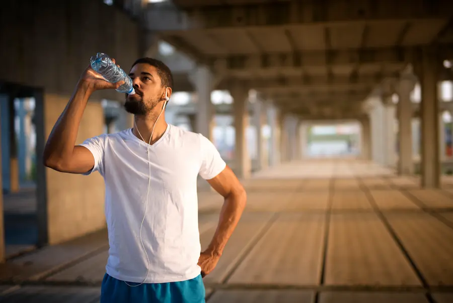 Corredor hidratándose adecuadamente después de entrenamiento cardiovascular intenso