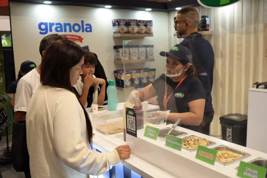 Corredora de la media maratón de Bogotá, revisando alternativas de alimentos pre-carrera en la expomedia 2025