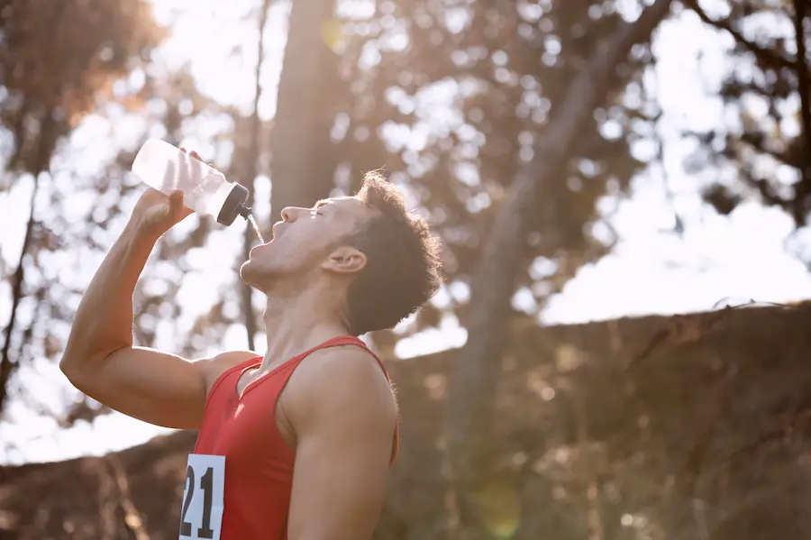 Runner rehidratándose después de completar exitosamente carrera de 10K