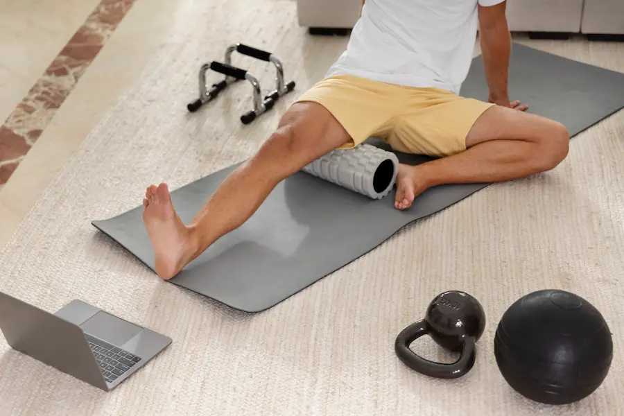Corredor usando foam roller correctamente con técnica apropiada para recuperación muscular