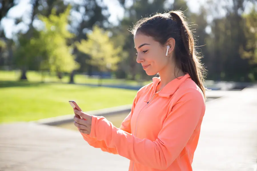 Runner ajustando playlist musical según beats por minuto objetivo para sesión de running