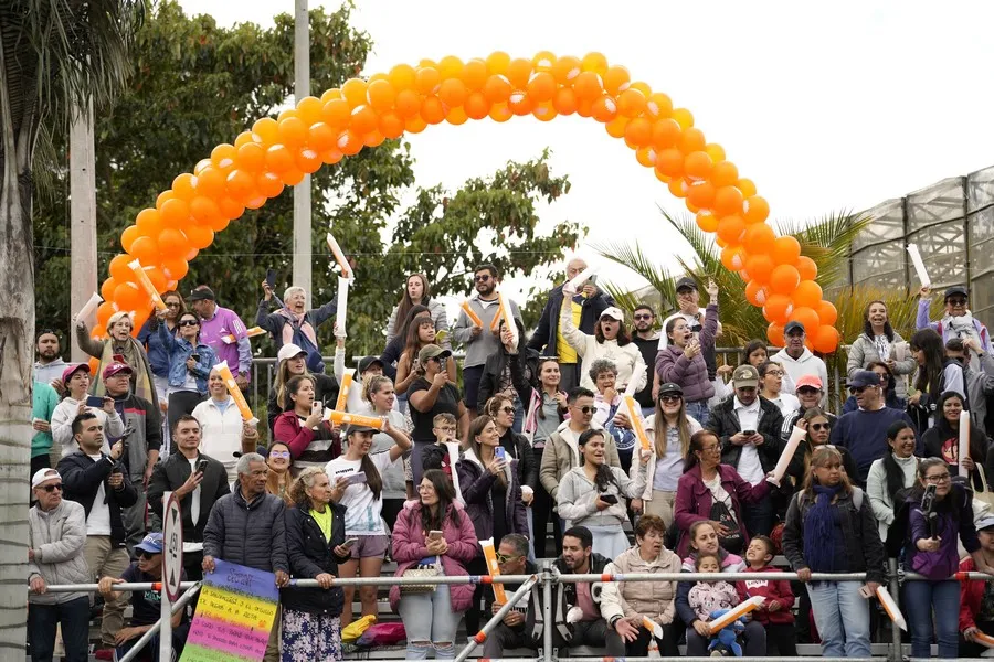 Zona de espectadores con multitud apoyando a participantes de media maratón en Bogotá