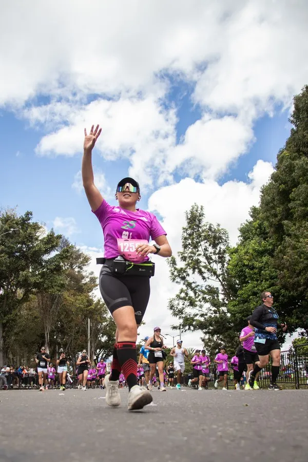 Corredora usando cinturón de hidratación con botellas durante la media maratón de Bogotá