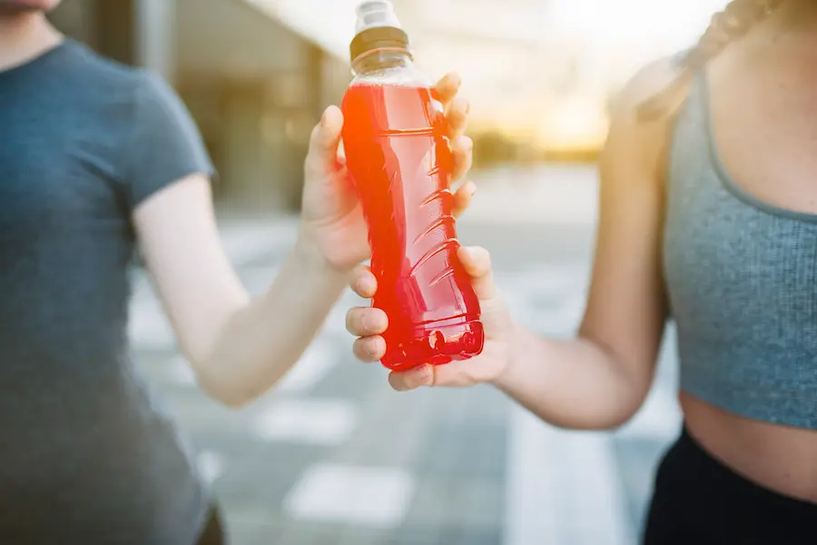 Runner consumiendo bebida deportiva luego de leer la etiqueta nutricional